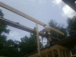 Carpenter setting a ridge beam over a new addition frame — Ice Dam Removal by Roofing Brothers in Grainfield